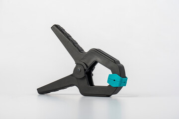 Black plastic spring clamp isolated on white background