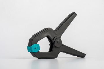 Black plastic spring clamp isolated on white background