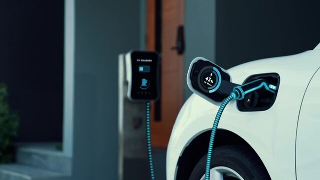 Woman recharge electric car with EV charger from home charging station in the garage. Technology advancement of EV car and home energy infrastructure for future sustainable power. Peruse