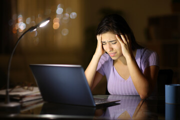 Concerned woman with laptop in the night