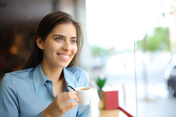 Happy elegant woman smiling drinking coffee in a bar