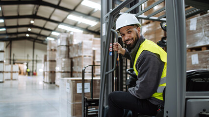 Portrait of warehouse worker driving forklift. Warehouse worker preparing products for shipmennt,...