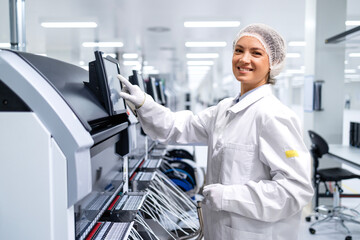 Portrait of female employee working in automobile industry assembly line.