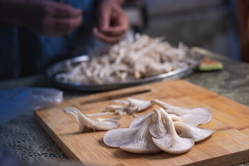 Fototapeta premium Delicious organic oyster mushrooms on wooden board at the kitchen.