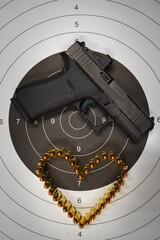 Theme of Valentine's day and weapons. A modern compact pistol with a red dot, a target and a heart...