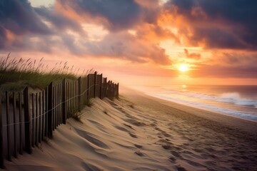  the sun is setting over the beach with a fence in the foreground and sand dunes in the foreground.