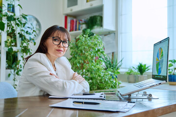 Portrait of mature woman working at home on computer laptop