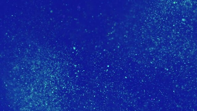 Particles background. Floating glitter. Abstract ocean depth. Silver shiny shimmer wave motion in blue marine water in creative bokeh spots fluid art.