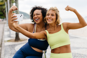 Friends taking a selfie in sportswear, celebrating a successful beach workout