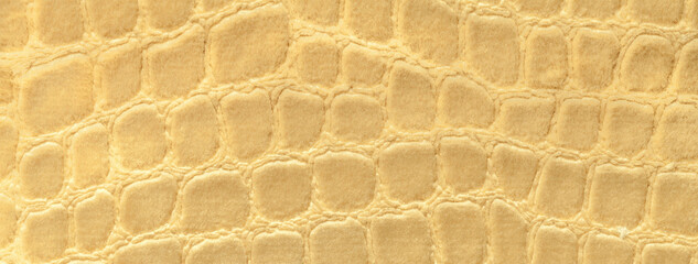 Light yellow background from soft upholstery textile material, closeup. Golden fabric with pattern
