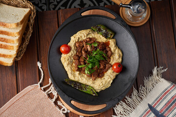 Top view photo of a lamb dish with baba ghanoush