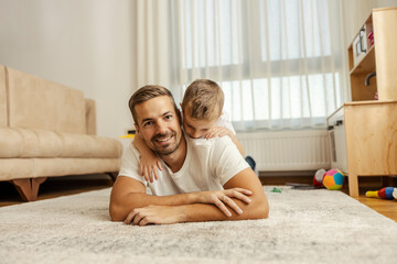 Portrait of a father and son playing at home.