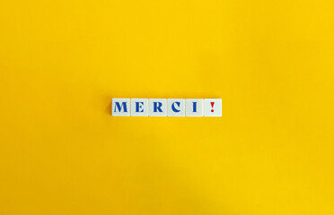 Merci Word on Letter Tiles on Yellow Orange Background. Minimalist Aesthetic.