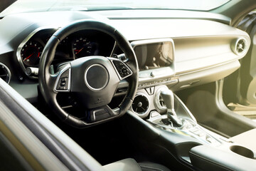 black interior of a modern car. Dashboard. Luxury leather steering wheel. Auto controls. Car doors inside. Car chairs and seats. Car sofa. Back and front row. Interior and door trim. High quality