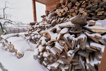 Firewood supplies for the winter lie under the snow