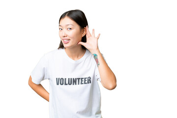 Young volunteer woman over isolated chroma key background listening to something by putting hand on the ear
