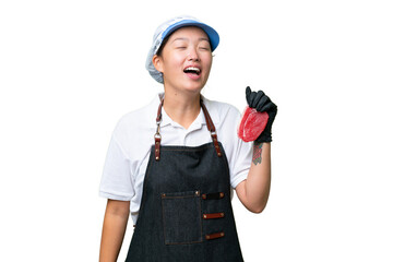 Young caucasian woman wearing an apron and serving fresh cut meat over isolated background laughing