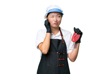 Young caucasian woman wearing an apron and serving fresh cut meat over isolated background frustrated and covering ears