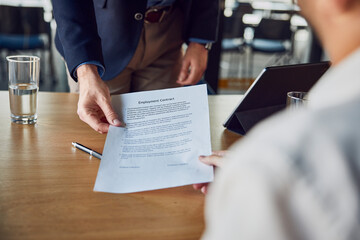 Recruiter giving contract to candidate at desk