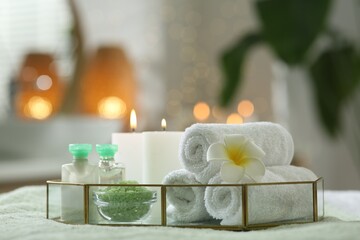 Composition with different spa products and burning candles on table indoors