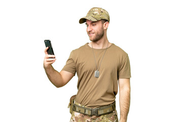 Military with dog tag over isolated chroma key background making a selfie