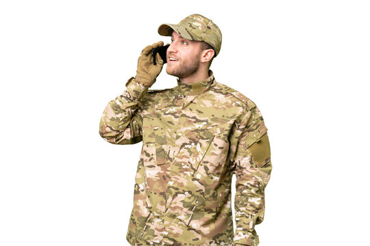 Military man over isolated chroma key background keeping a conversation with the mobile phone