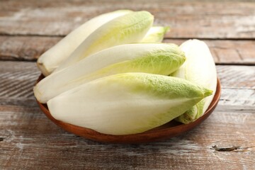 Fresh raw Belgian endives (chicory) on wooden table