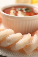 Fototapeta na wymiar Tasty boiled shrimps with cocktail sauce and lemon on plate, closeup