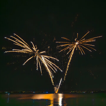 Italy, Veneto, Fireworks exploding over lake Garda at night