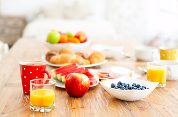 Coffee with fruit, cereal and croissant on wooden table background