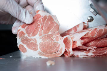 Pork that has been wrapped until it becomes a ball. Slide through Meat automatic slicer into round...