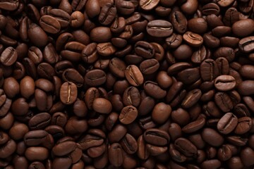 Obraz premium Close up view of dark fresh roasted coffee beans on coffee beans background. Closeup of coffee beans scattered background
