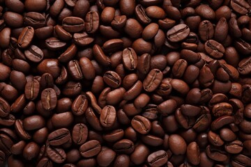 Fototapeta premium Close up view of dark fresh roasted coffee beans on coffee beans background. Closeup of coffee beans scattered background
