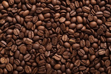 Obraz premium Close up view of dark fresh roasted coffee beans on coffee beans background. Closeup of coffee beans scattered background