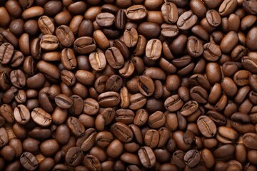 Close up view of dark fresh roasted coffee beans on coffee beans background. Closeup of coffee beans scattered background