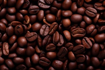 Obraz premium Close up view of dark fresh roasted coffee beans on coffee beans background. Closeup of coffee beans scattered background