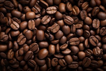 Close up view of dark fresh roasted coffee beans on coffee beans background. Closeup of coffee beans scattered background
