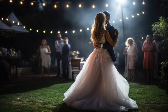 Bride and Groom dancing at wedding reception outside in the evening.