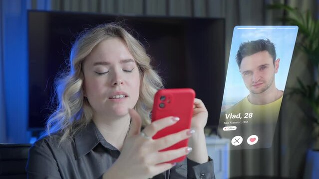 Visual concept of the young woman using dating app on smartphone and gets a match. Attractive blonde woman in modern home interior looking for a man in a dating app