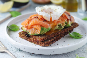 A rye bread sandwich with avocado and salmon	