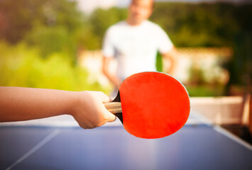 Unrecognizable child plying ping pong with father