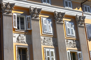 Facade of the Italian palace with details, featuring ornate stucco embellishments and majestic columns