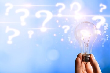 Businessman holding classic light bulb with question marks