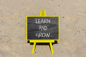 Learn and grow symbol. Concept word Learn And Grow on beautiful black chalk blackboard. Sand beach. Beautiful sand beach background. Business, education learn and grow concept. Copy space.