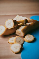 Close-up of peeled sliced banana on wooden table background