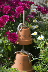 Trough container with dwarf pink chrysanthemum and terracotta pots with words Peace and Love on them.