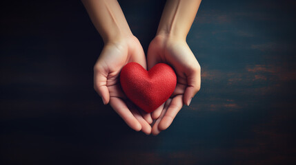 Obraz premium Top view photo of hands holding red heart on black background, healthcare, love, organ donation, mindfulness, wellbeing, family insurance and CSR concept, World Heart Day.