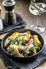 Healthy salad with goat cheese, lettuce, pears and pomegranate