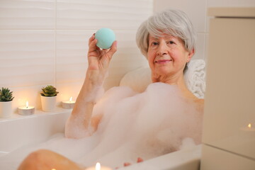 Senior woman enjoying a blue bath bomb 