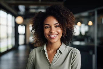 Foto op Aluminium Smiling African American lady with curly hair and casual clothing standing in an office, radiating happiness and beauty © pantip